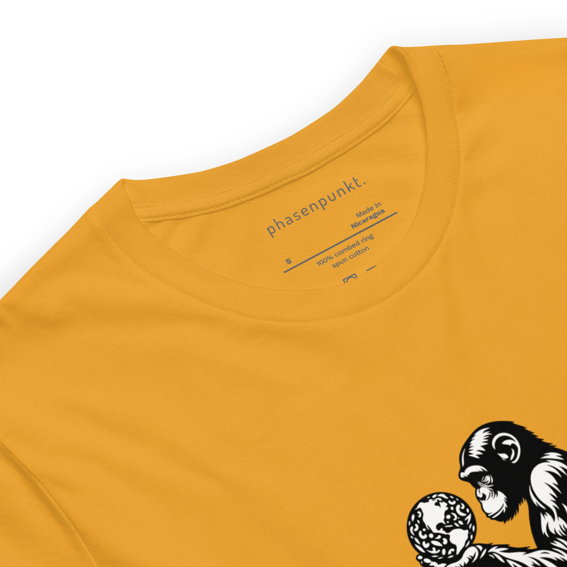 Close-up of a yellow T-shirt showing the phasenpunkt branding on the inside collar and part of the stylized design featuring a monkey holding a globe.